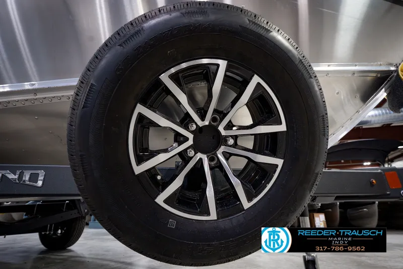 Slide: The Image of Close-up of a 2026 Lund 1800 Explorer SS boat trailer wheel with sleek black and silver design. - 56