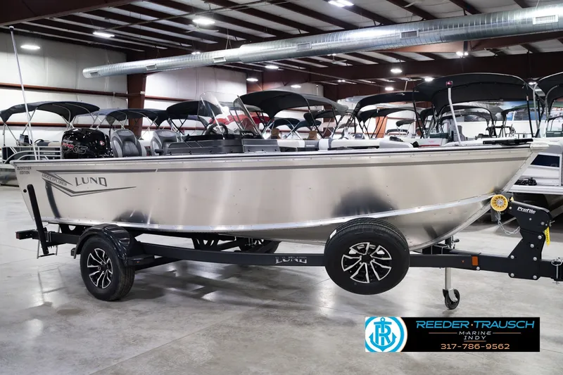 Slide: The Image of 2026 Lund 1800 Explorer SS boat on trailer in showroom, featuring sleek design and modern features. - 4