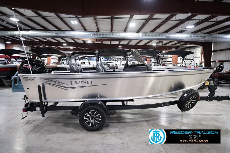 Slide: The Image of 2026 Lund 1800 Explorer SS boat in showroom, side view, on trailer. - 5