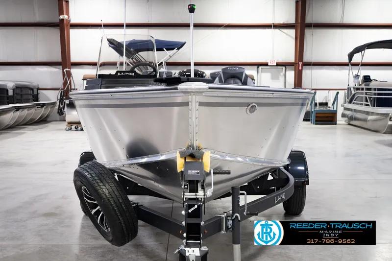 Slide: The Image of 2026 Lund 1800 Explorer SS boat on trailer in indoor showroom. - 2