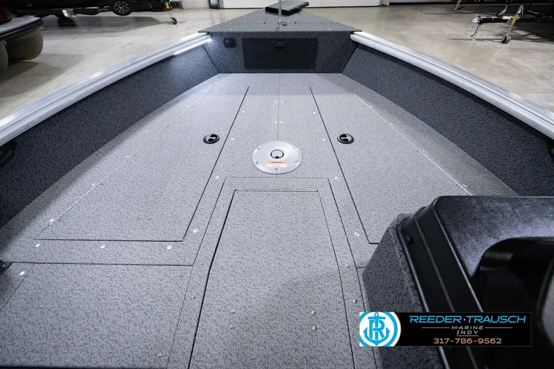 Slide: The Image of 2026 Lund 1800 Explorer SS boat interior with gray flooring and storage compartments. - 20