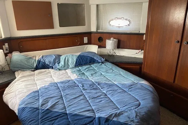 Slide: The Image of Cozy bedroom in 2000 Carver 406 Aft Cabin Motor Yacht with blue bedding. - 31