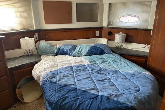 Slide: The Image of Cozy bedroom in 2000 Carver 406 Aft Cabin Motor Yacht with blue bedding. - 37