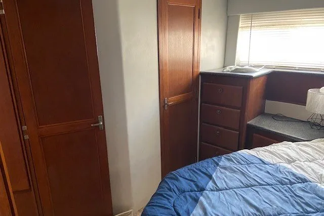 Slide: The Image of Interior of 2000 Carver 406 Aft Cabin Motor Yacht bedroom with wooden cabinets and bed. - 35