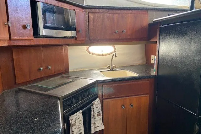 Slide: The Image of Interior kitchen of 2000 Carver 406 Aft Cabin Motor Yacht with wooden cabinets. - 25