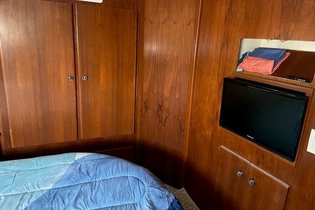 Slide: The Image of Interior of 2000 Carver 406 Aft Cabin Motor Yacht with wood paneling and TV. - 30