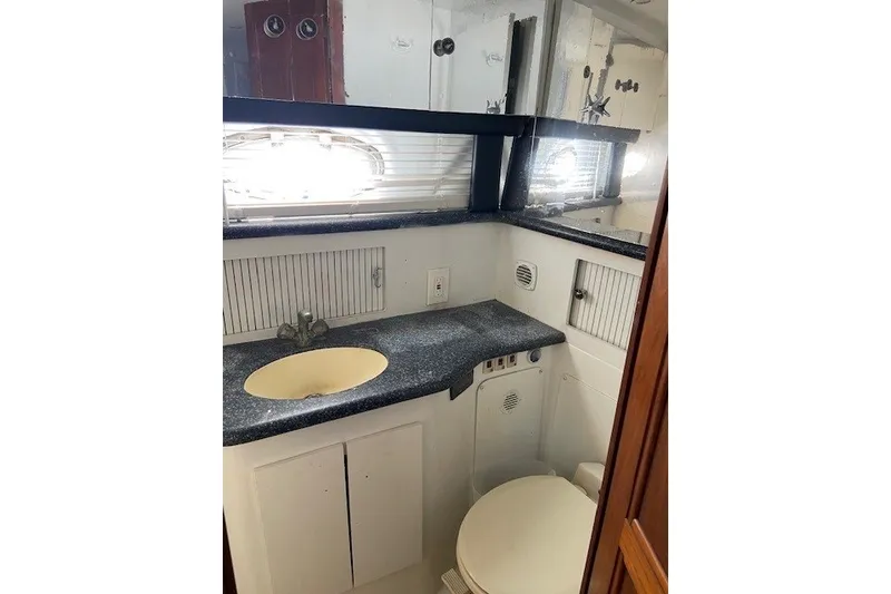 Slide: The Image of Bathroom interior of 2000 Carver 406 Aft Cabin Motor Yacht, featuring sink and toilet. - 32