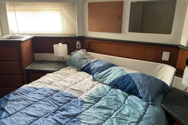 Slide: The Image of Cozy bedroom in 2000 Carver 406 Aft Cabin Motor Yacht with blue bedding. - 34
