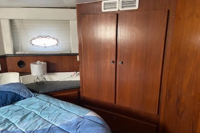 Slide: The Image of Interior of 2000 Carver 406 Aft Cabin Motor Yacht with wood cabinetry and cozy bedding. - 36