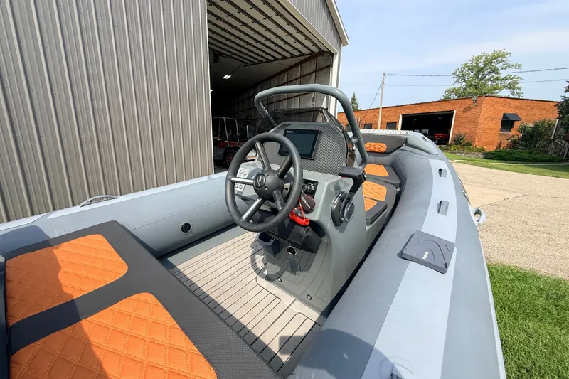 Slide: The Image of 2023 Highfield Sport 420 boat interior with orange seats and steering console. - 10
