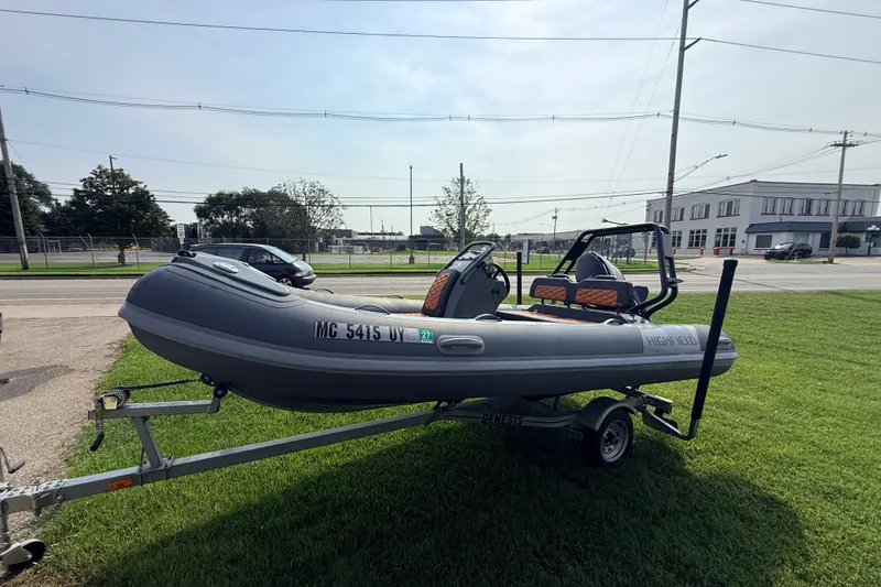Slide: The Image of 2023 Highfield Sport 420 inflatable boat on trailer, parked on grass. - 5