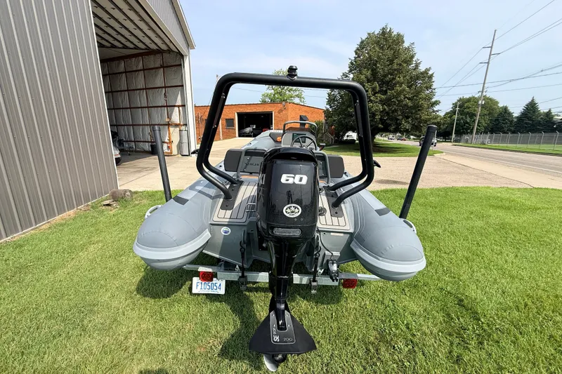 Slide: The Image of 2023 Highfield Sport 420 boat with 60 HP engine, parked on grass near a building. - 11