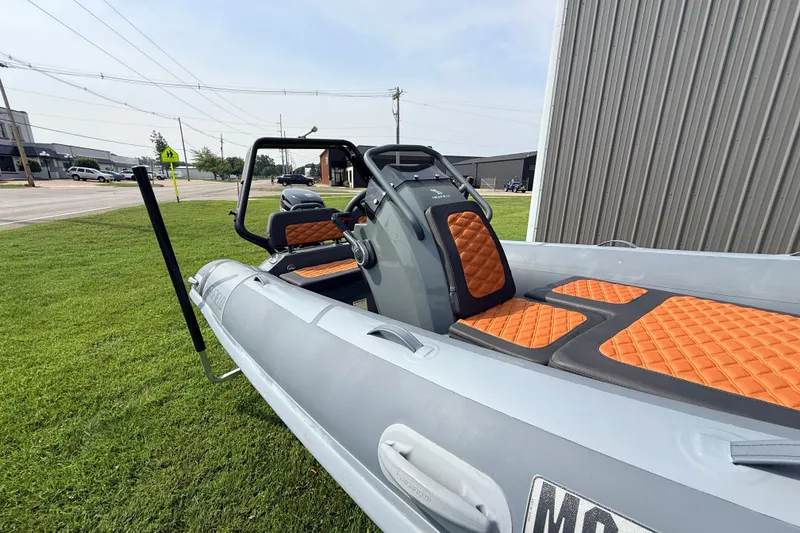 Slide: The Image of 2023 Highfield Sport 420 boat with orange seats, parked on grass near a building. - 18