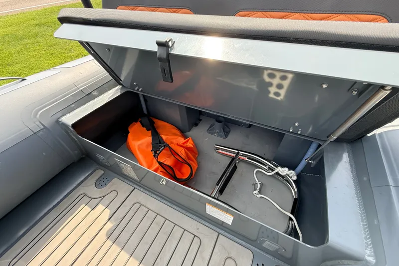 Slide: The Image of Open storage compartment in 2023 Highfield Sport 420 boat with orange bag and equipment. - 19