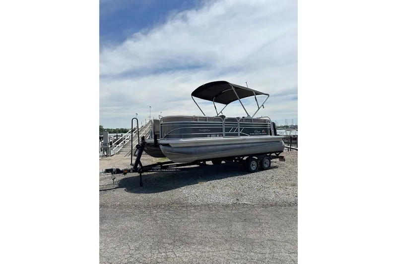 The Image of 2022 SUNTRACKER Party Barge pontoon boat on trailer under a cloudy sky. - 0
