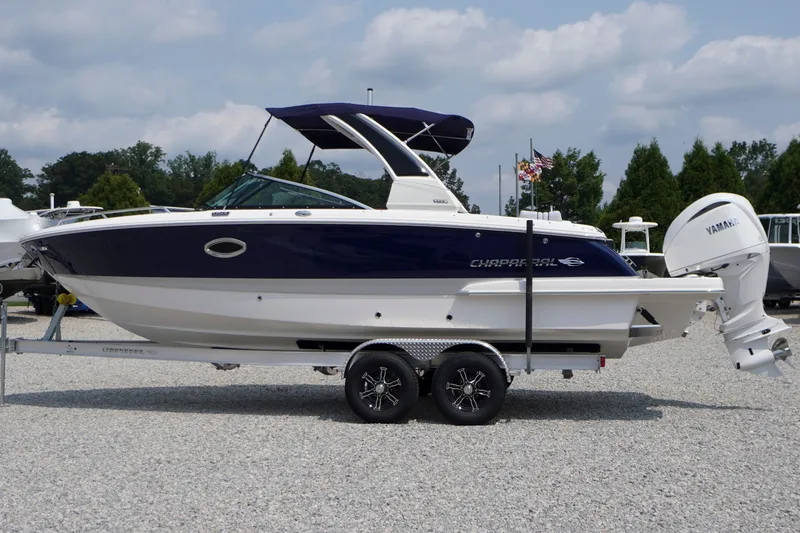 Slide: The Image of 2027 Chaparral 270 OSX boat on trailer, displayed outdoors under cloudy sky. - 1