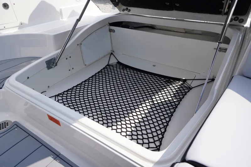 Slide: The Image of Open storage compartment with netting in 2027 Chaparral 270 OSX boat. - 56