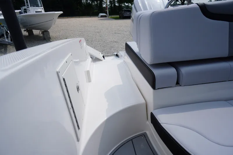 Slide: The Image of 2027 Chaparral 270 OSX boat interior with white seating and storage compartment. - 59