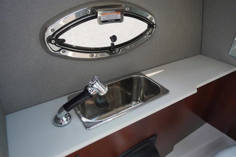 Slide: The Image of Interior sink area of 2027 Chaparral 270 OSX boat with oval window and faucet. - 24