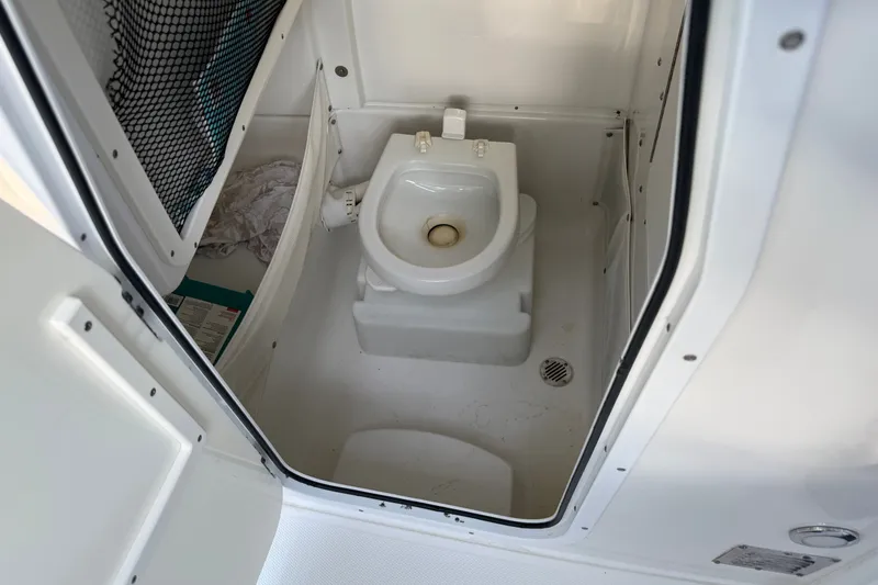 Slide: The Image of 2018 Sea Hunt Gamefish 27 boat toilet compartment, featuring a compact marine toilet. - 42