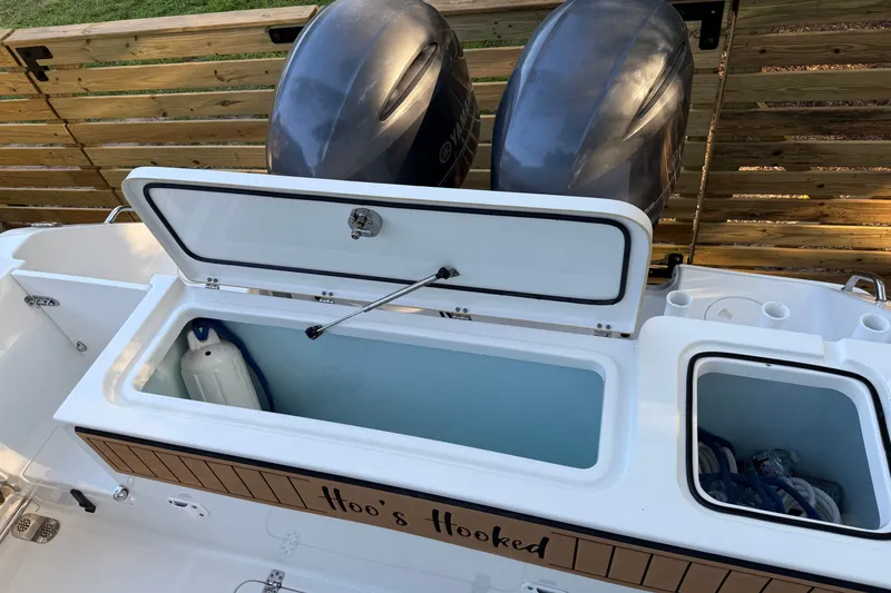 Slide: The Image of 2018 Sea Hunt Gamefish 27 boat with open storage compartment and twin engines. - 19