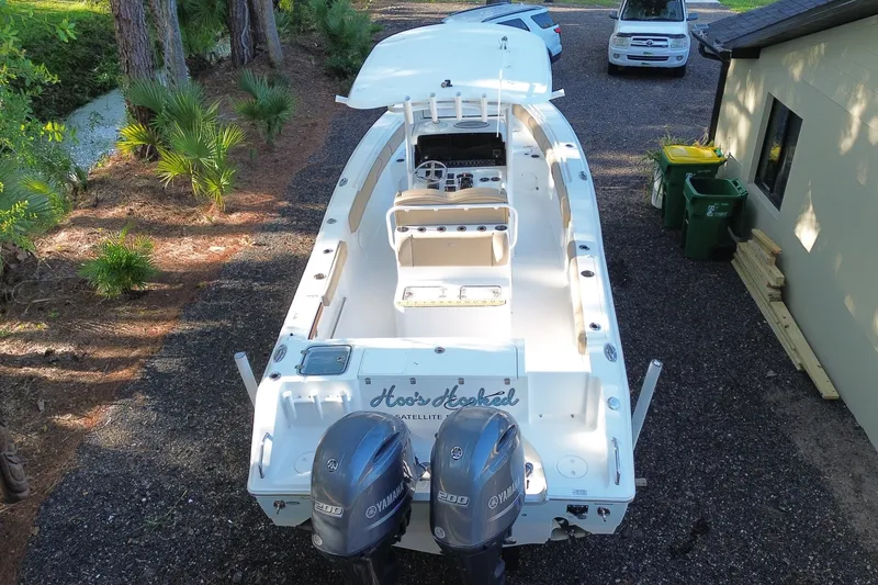 Slide: The Image of 2018 Sea Hunt Gamefish 27 boat with dual Yamaha engines parked on gravel driveway. - 3