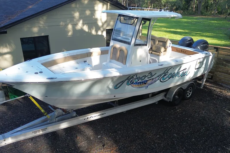 The Image of 2018 Sea Hunt Gamefish 27 boat on trailer, parked outdoors near a house. - 0