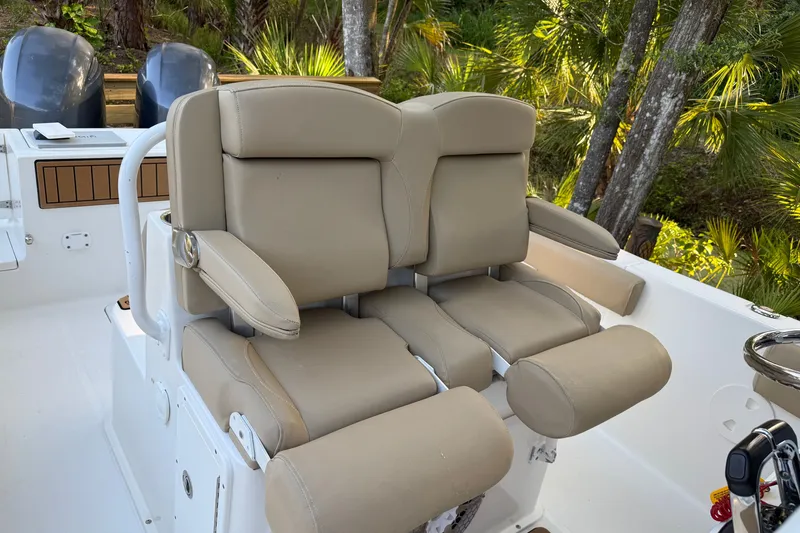 Slide: The Image of 2018 Sea Hunt Gamefish 27 boat with beige cushioned seats and dual outboard motors. - 29