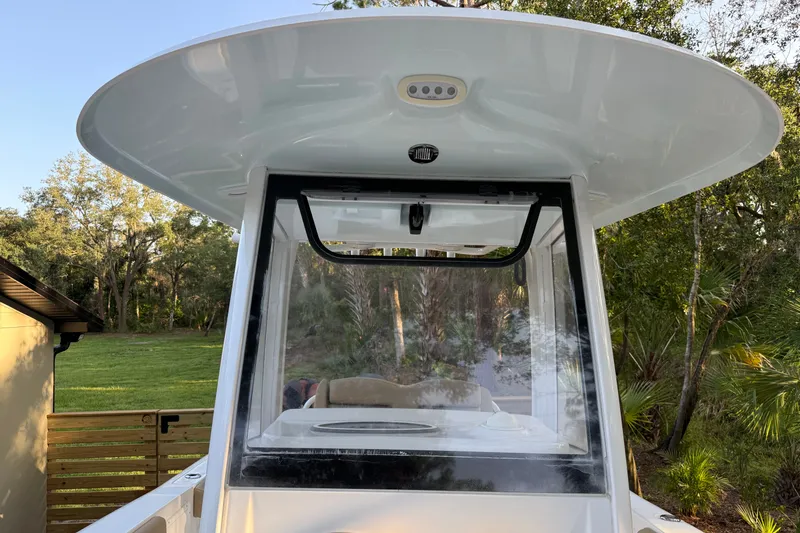 Slide: The Image of 2018 Sea Hunt Gamefish 27 boat with T-top and windshield, surrounded by greenery. - 40