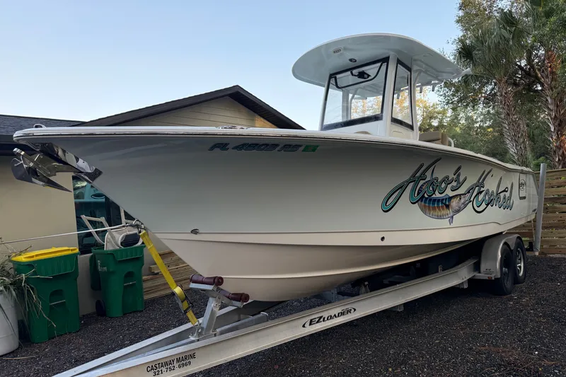 Slide: The Image of 2018 Sea Hunt Gamefish 27 boat on trailer, parked near house and trees. - 57