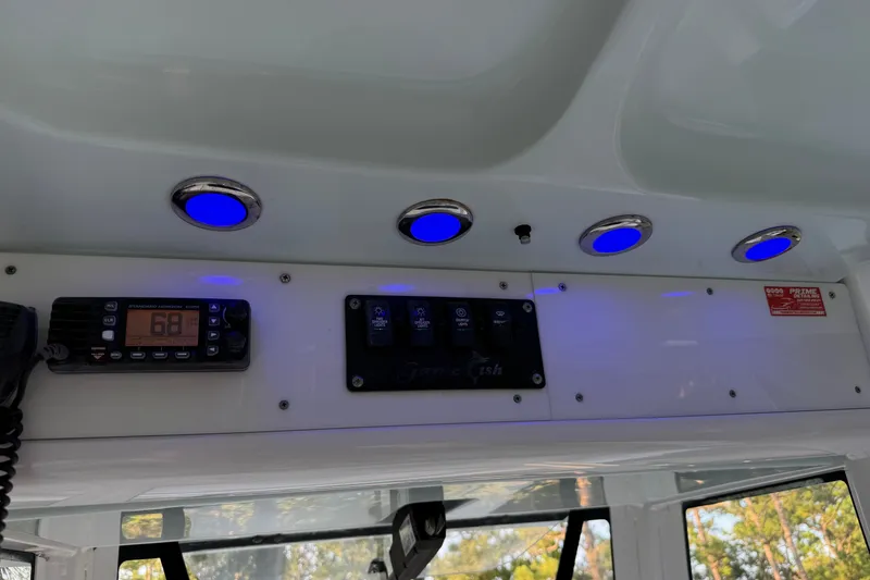 Slide: The Image of 2018 Sea Hunt Gamefish 27 dashboard with blue LED lights and radio controls. - 51
