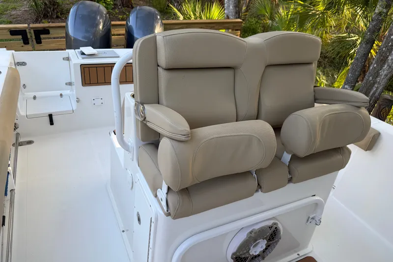 Slide: The Image of 2018 Sea Hunt Gamefish 27 boat interior with beige seating and dual engines. - 30
