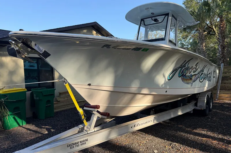 Slide: The Image of 2018 Sea Hunt Gamefish 27 boat on trailer, parked outdoors near trees. - 10