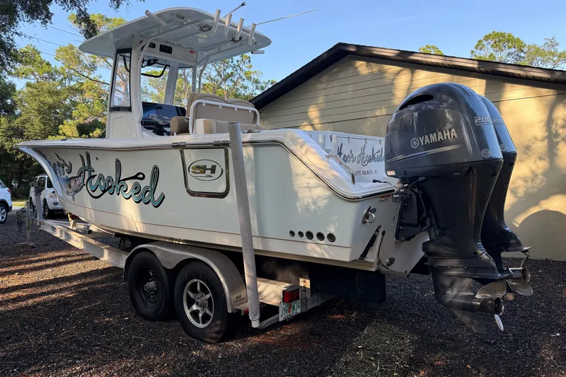 Slide: The Image of 2018 Sea Hunt Gamefish 27 boat on trailer with Yamaha engines, parked outdoors. - 12