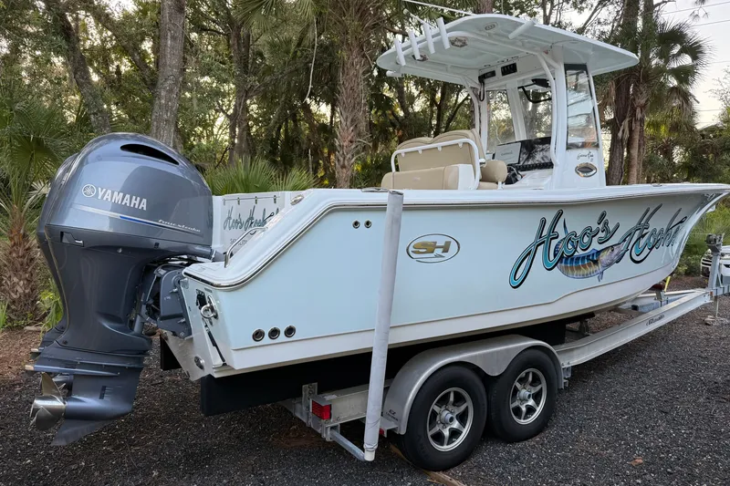 Slide: The Image of 2018 Sea Hunt Gamefish 27 boat with Yamaha engine on trailer, parked outdoors. - 54