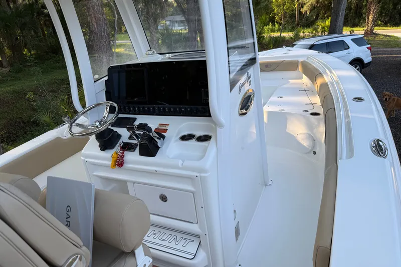 Slide: The Image of 2018 Sea Hunt Gamefish 27 boat interior with helm, steering wheel, and seating. - 23