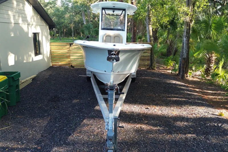 Slide: The Image of 2018 Sea Hunt Gamefish 27 boat on trailer, parked in a wooded area. - 7