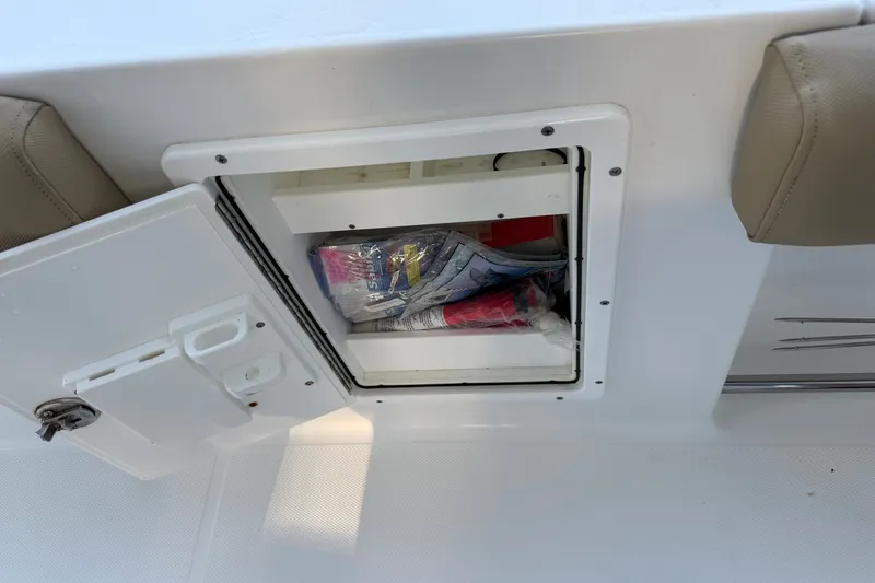 Slide: The Image of Open storage compartment on 2018 Sea Hunt Gamefish 27 boat, containing various items. - 27