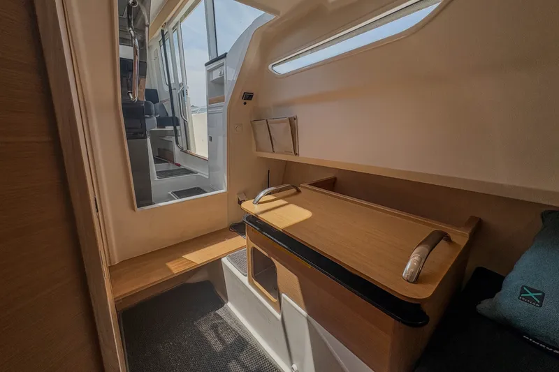 Slide: The Image of Interior of 2024 Nimbus Commuter 9 boat, featuring a compact cabin with wooden accents. - 17