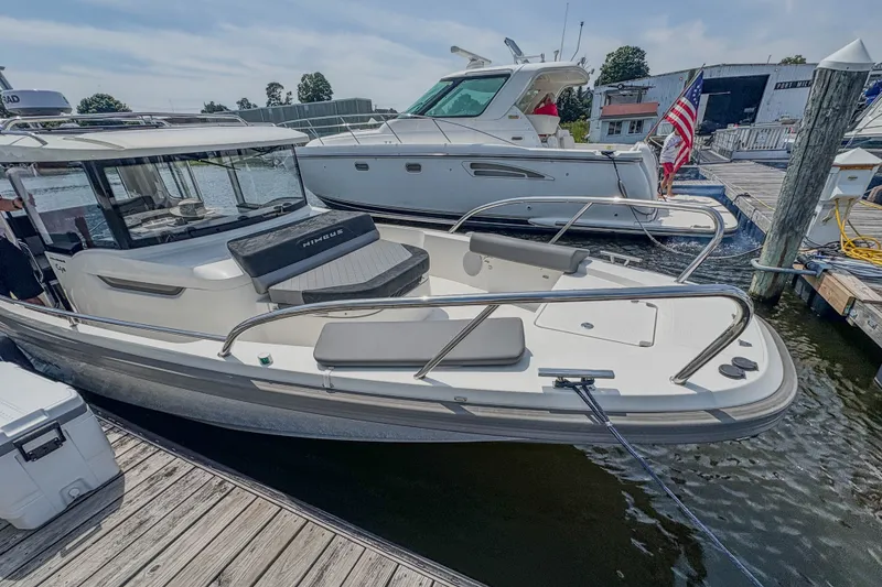 Slide: The Image of 2024 Nimbus Commuter 9 boat docked at marina, sleek design, sunny day. - 8