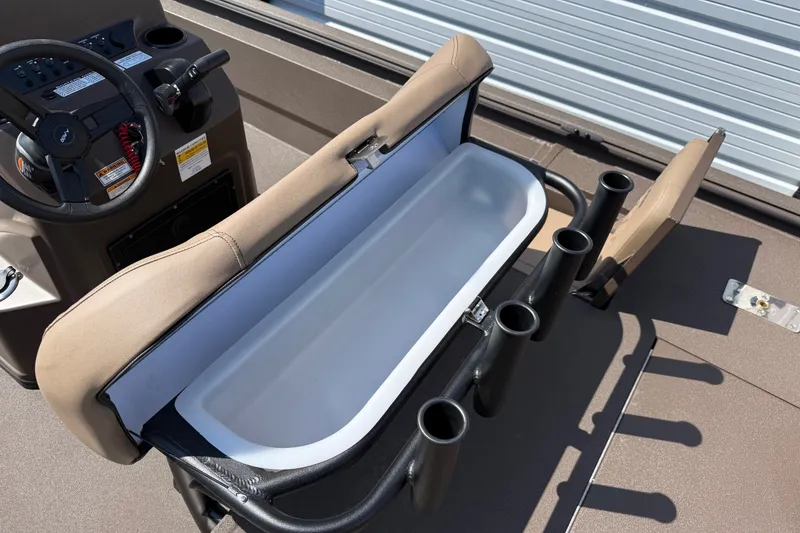 Slide: The Image of 2027 Avid 20 Rogue CC boat interior with open storage compartment and rod holders. - 16