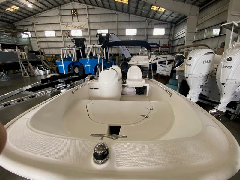 Slide: The Image of A 2017 Boston Whaler 130 Super Sport in a warehouse, surrounded by other boats. - 3