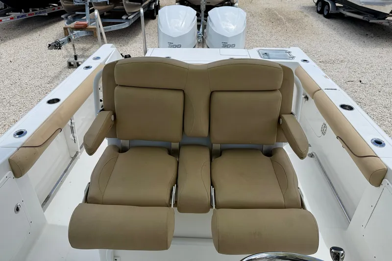 Slide: The Image of 2016 Sea Hunt Gamefish 30 boat with tan cushioned seating and dual outboard motors. - 24
