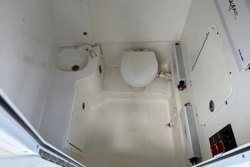 Slide: The Image of Compact bathroom in 2016 Sea Hunt Gamefish 30 boat, featuring toilet and sink. - 28