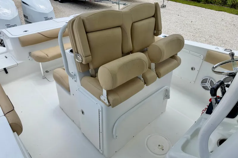 Slide: The Image of 2016 Sea Hunt Gamefish 30 boat interior with beige seating and steering wheel. - 23