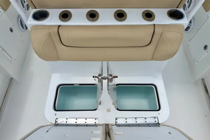 Slide: The Image of 2016 Sea Hunt Gamefish 30 boat interior with beige seating and storage compartments. - 26