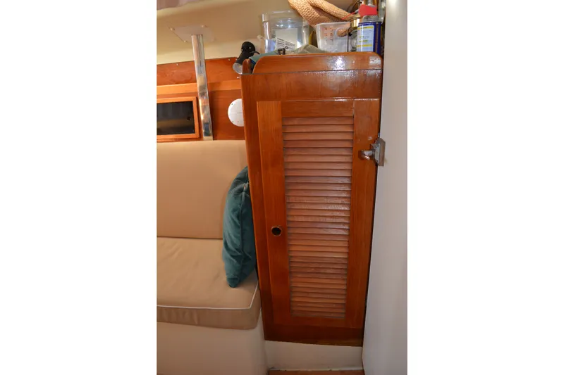 Slide: The Image of Interior of 1984 Pearson 303 sailboat with wooden cabinet and beige seating. - 15