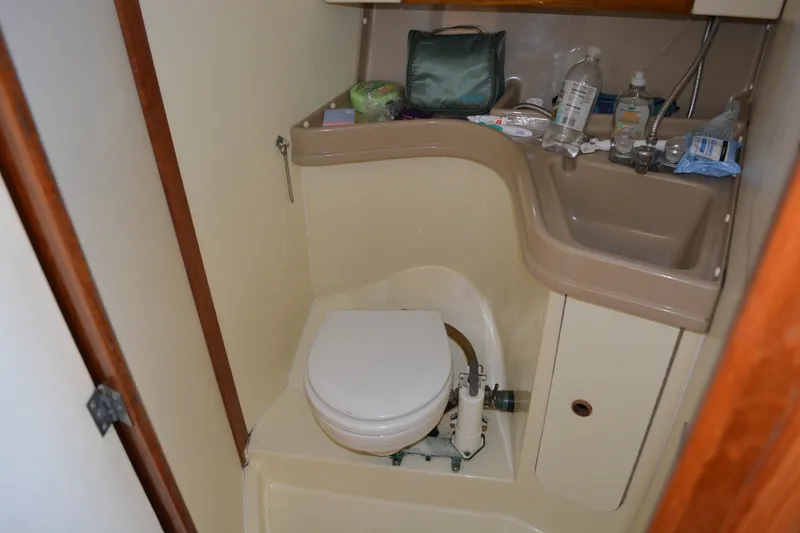 Slide: The Image of Compact bathroom in a 1984 Pearson 303 sailboat with toilet and sink. - 16