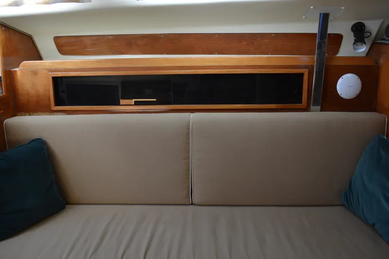 Slide: The Image of Interior of 1984 Pearson 303 sailboat with beige sofa and wooden cabinetry. - 13