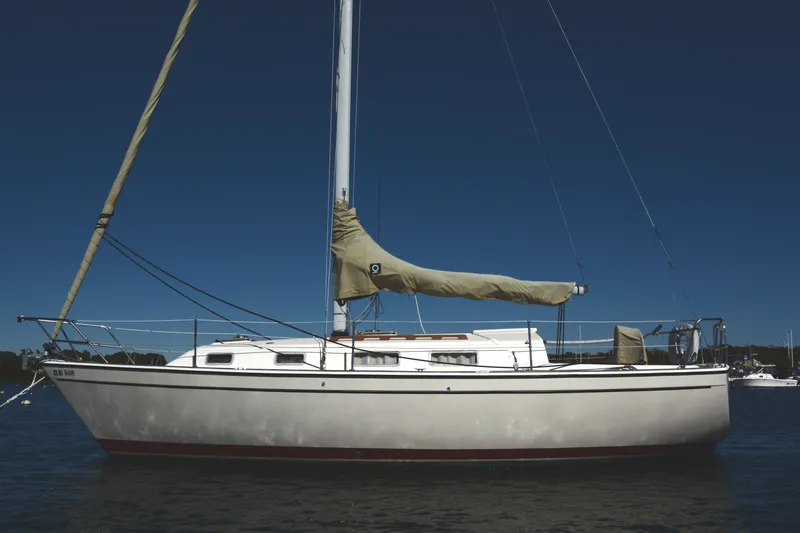 The Image of 1984 Pearson 303 sailboat on calm water under clear blue sky. - 0